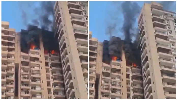 Noida Sector 119 fire showing black smoke rising from The Aranya Society after a reported AC blast on the 21st floor.